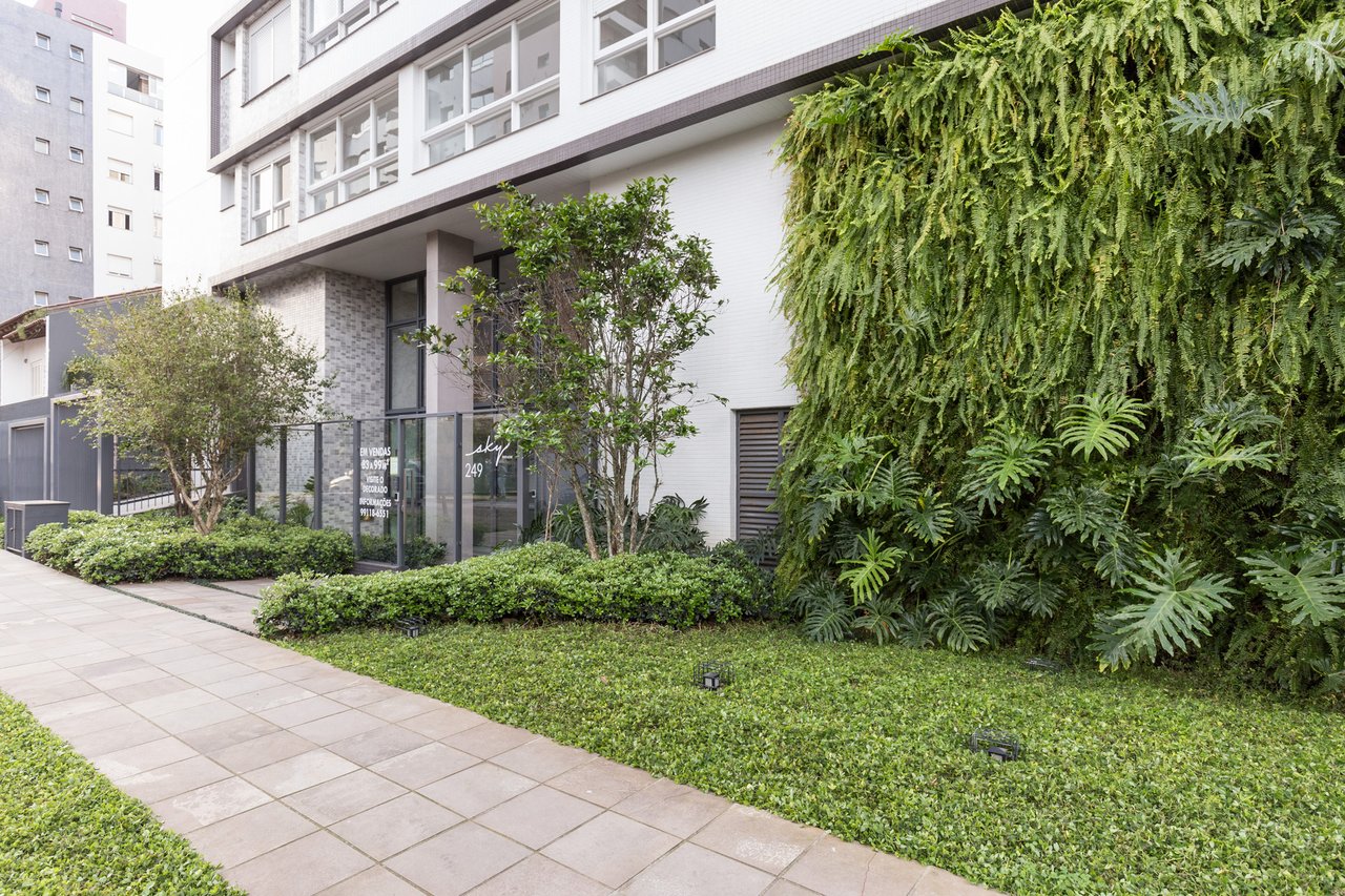 Fachada ativa do Sky com jardim vertical de samambaias e entrada envidraçada no número 249