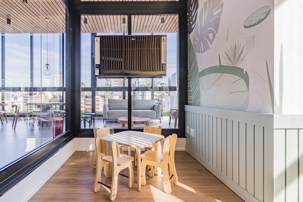 Espaço kids do Z800 com mesa e cadeiras infantis em madeira, painel decorativo tropical e vista panorâmica