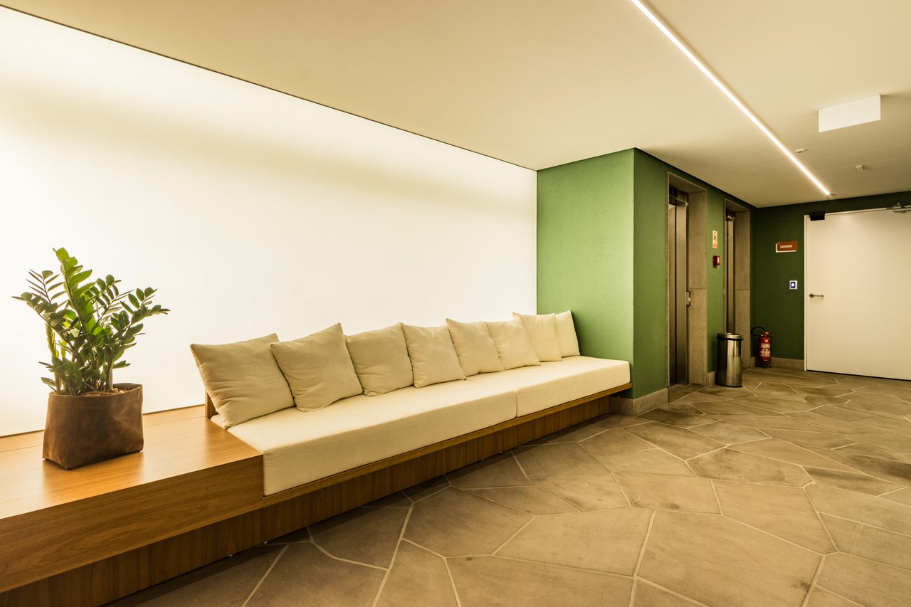 Hall decorado de entrada do Artus, com portaria em madeira ripada