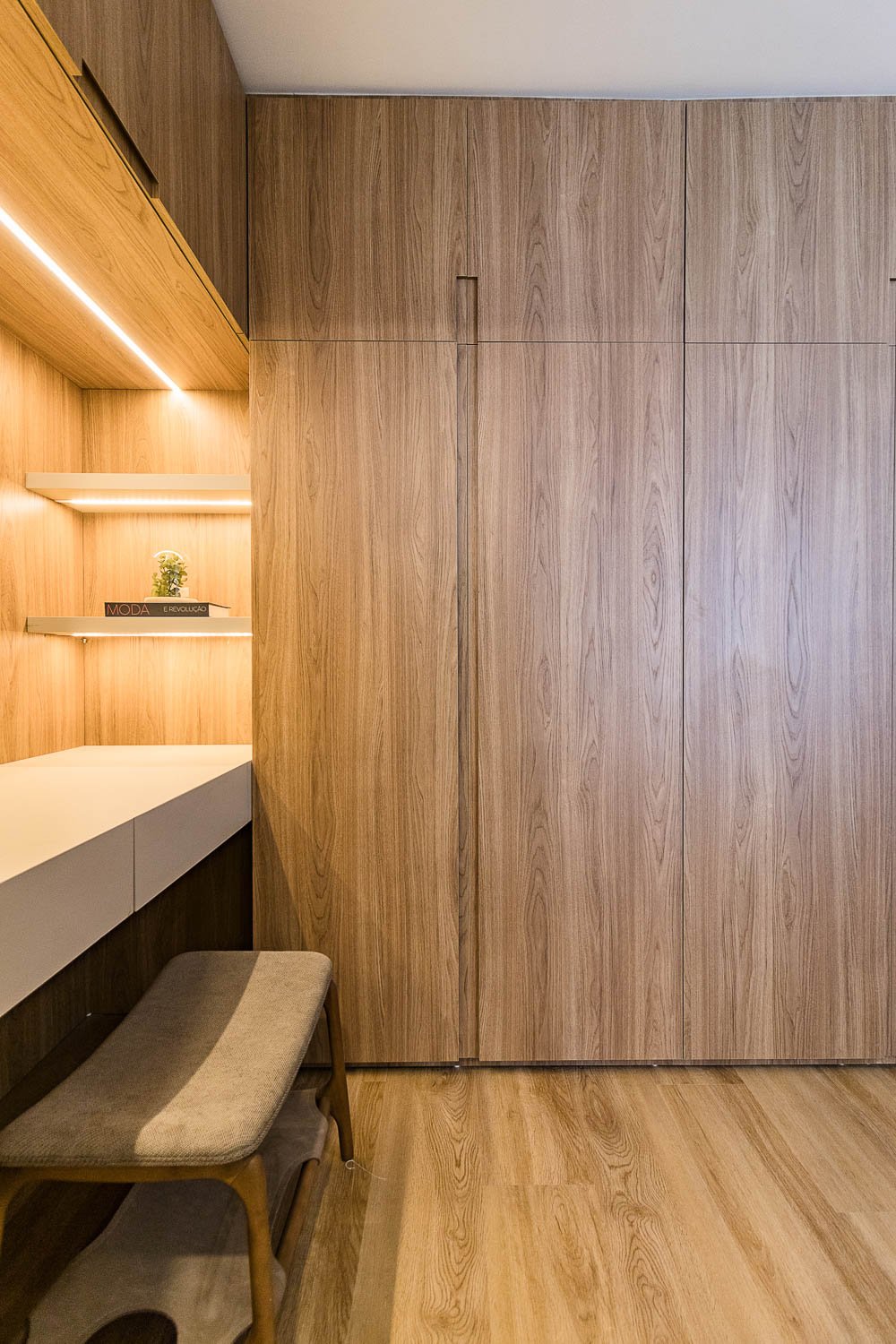 Closet da suíte do Z800 com marcenaria em madeira e bancada iluminada