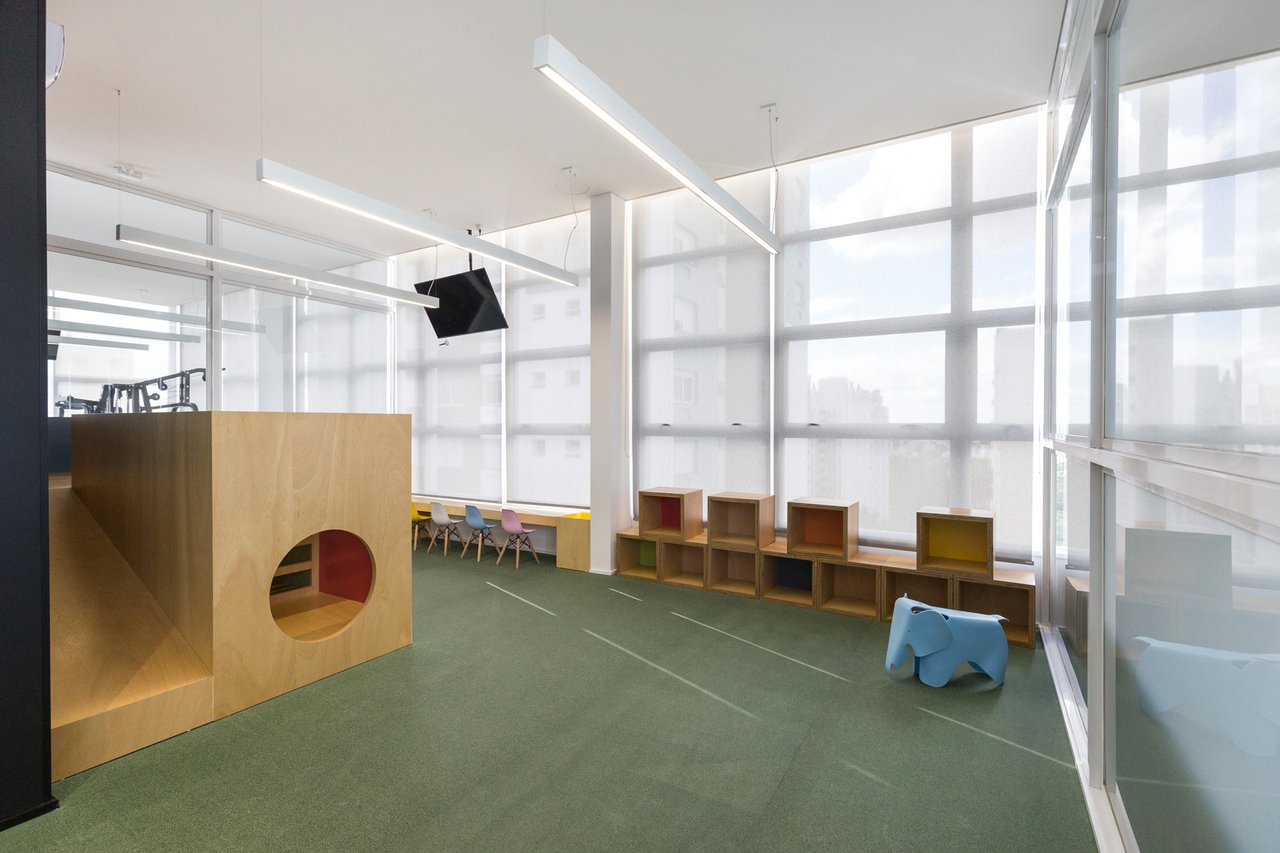 Espaço kids do Sky com piso verde, casinha de madeira, nichos coloridos e vista panorâmica