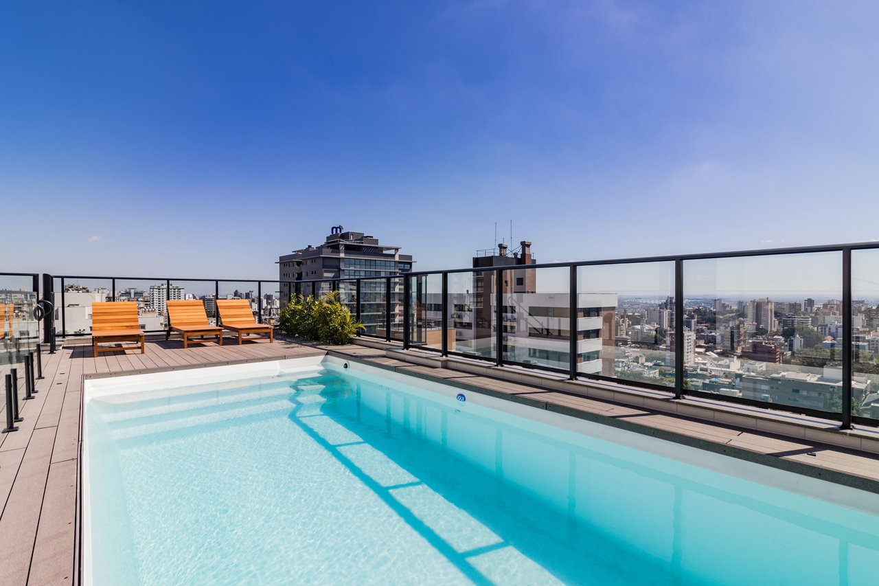 Piscina rooftop do Z800 com espreguiçadeiras em madeira e vista panorâmica de Porto Alegre